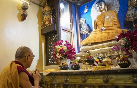 达赖喇嘛尊者在印度菩提伽耶大佛塔内向佛陀释迦牟尼十二岁等身像祈祷 照片/ 资料图片/ OHHDL